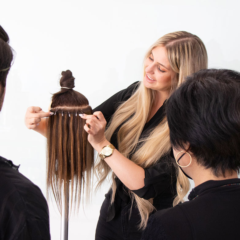 Class instructor demonstrating how to apply One-Step Weft extensions