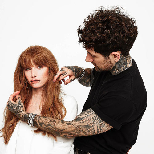 Hair stylist using their hands to fix hair of a model posing for the camera